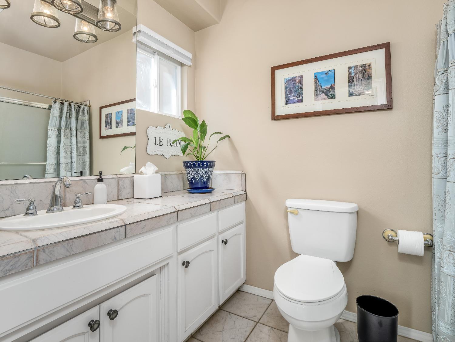 12 Breeze Way Madera, CA 93637 - Photo 20 of 48 a bathroom with a toilet sink and mirror
