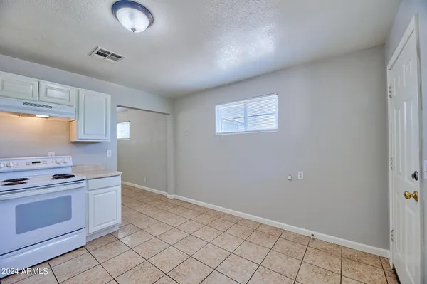 a kitchen with granite countertop white cabinets and white appliances