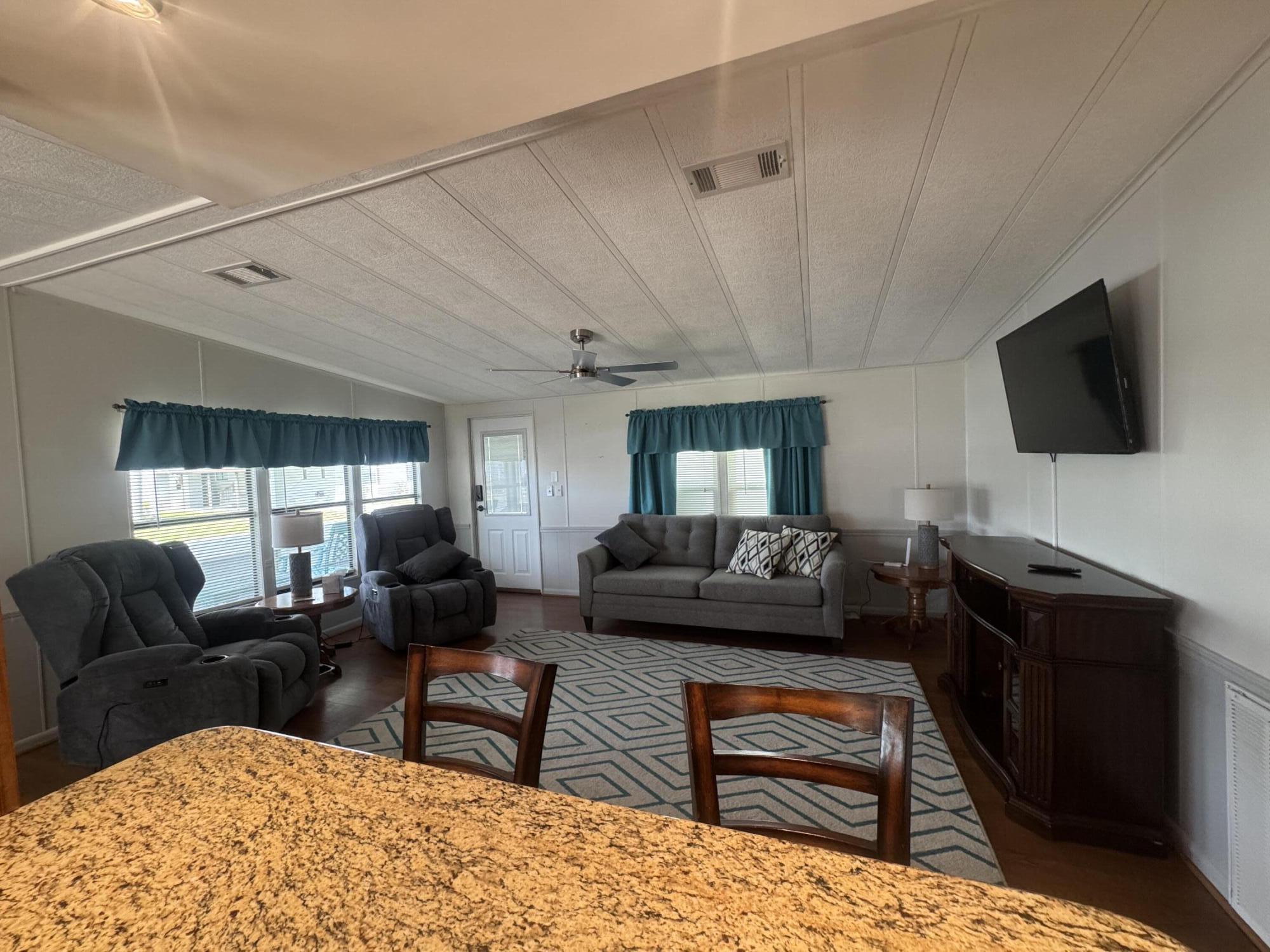1747 Southwest 35th Circle Okeechobee, FL 34974 - Photo 11 of 21 a living room with furniture and a flat screen tv