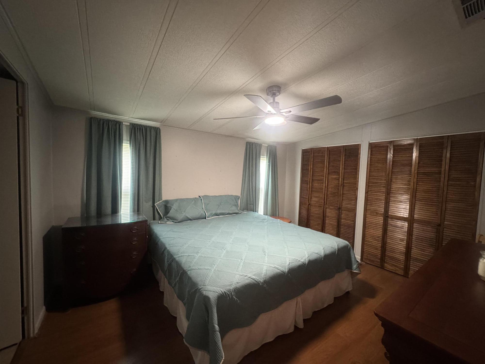 1747 Southwest 35th Circle Okeechobee, FL 34974 - Photo 14 of 21 a bedroom with a bed and a chandelier
