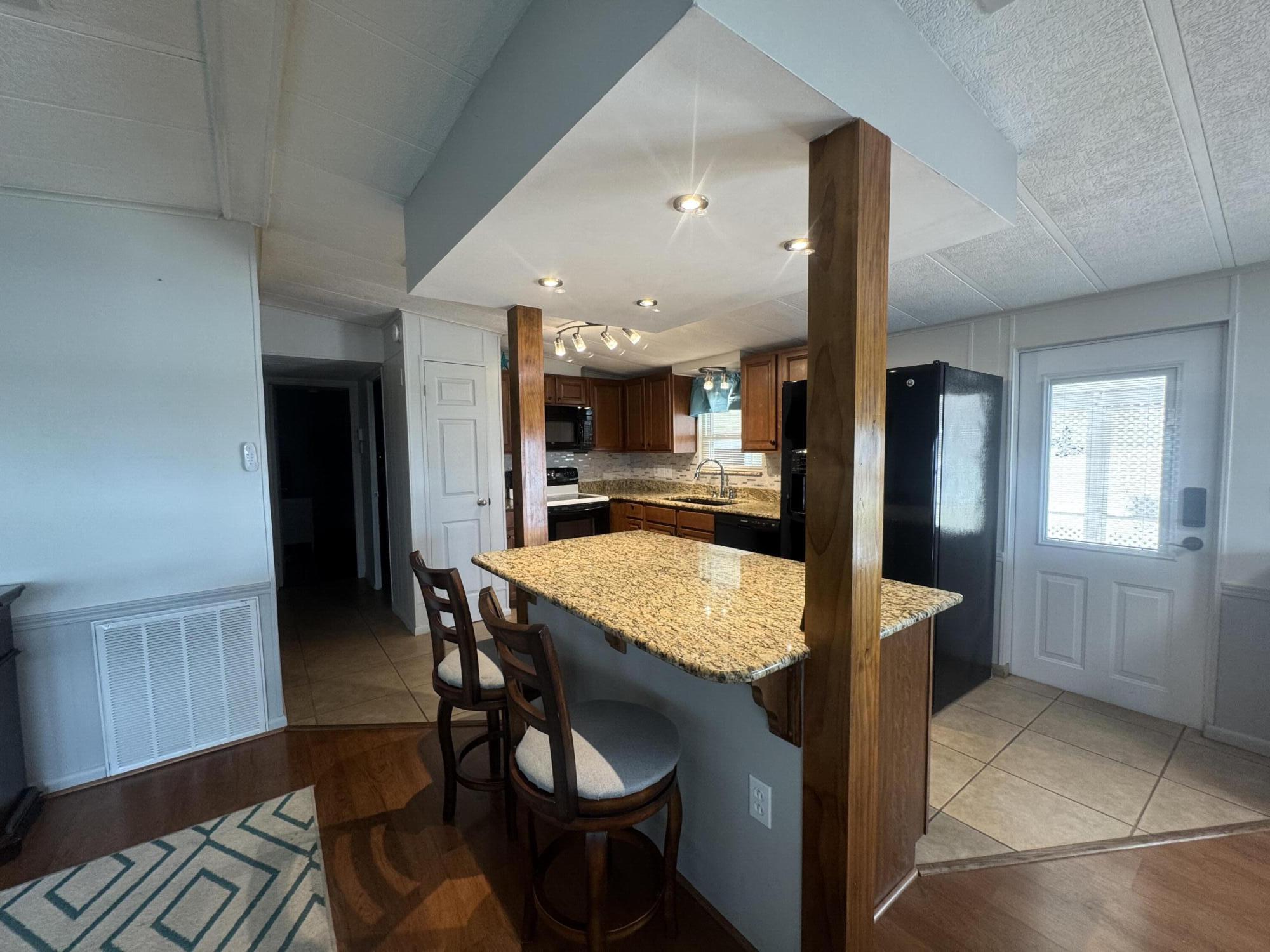 1747 Southwest 35th Circle Okeechobee, FL 34974 - Photo 7 of 21 a dining hall with stainless steel appliances kitchen island granite countertop furniture and wooden floor