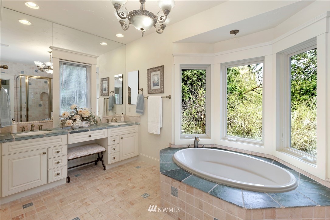 764 Big Foot Road Friday Harbor, WA 98250 - Photo 15 of 34 a bathroom with a granite countertop sink a large mirror and a bathtub next to a window