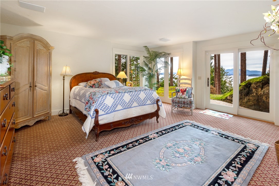 764 Big Foot Road Friday Harbor, WA 98250 - Photo 19 of 34 a bedroom with a bed lamp and a large window