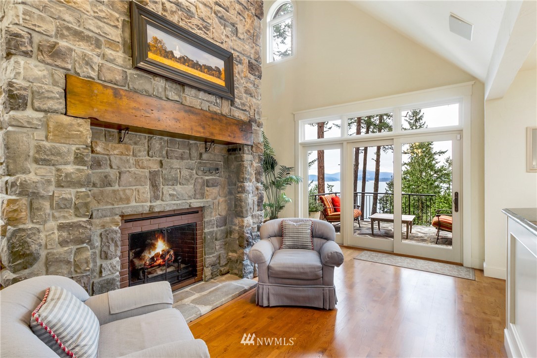 764 Big Foot Road Friday Harbor, WA 98250 - Photo 6 of 34 a living room with furniture a fireplace and a floor to ceiling window