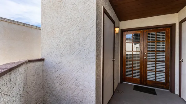 a view of a hallway with wooden floor and windows