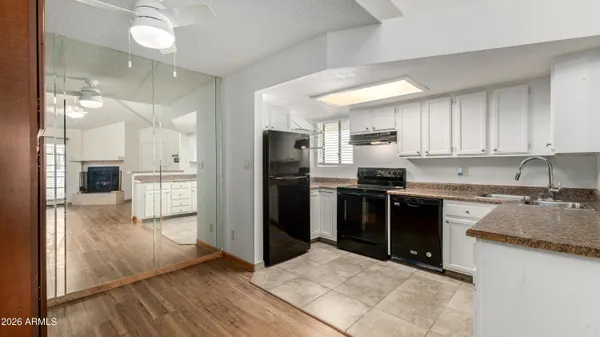 a kitchen with granite countertop a refrigerator and a stove top oven