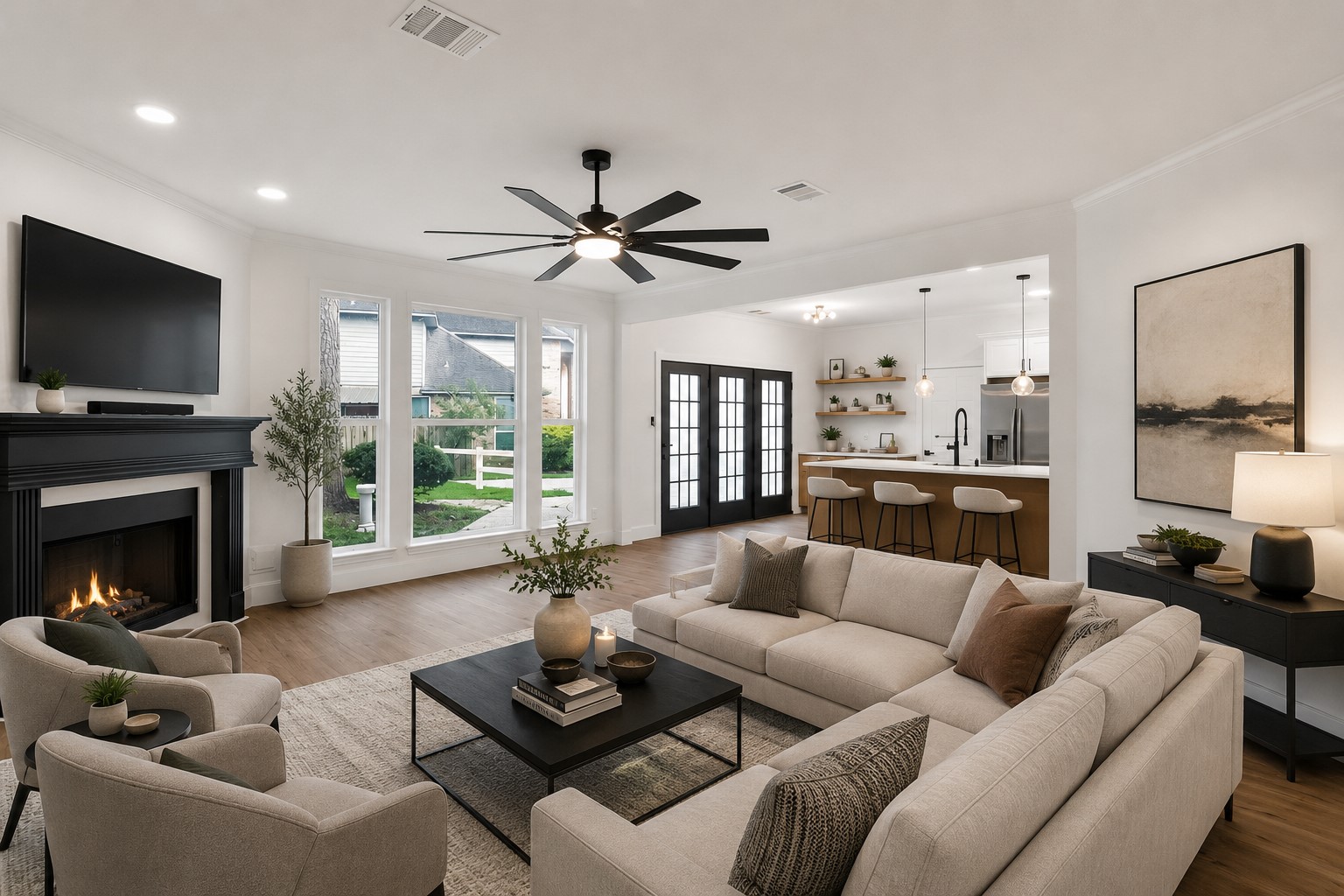 523 Rampart Lane Conroe, TX 77302 - Photo 4 of 23 Spacious and inviting living area featuring a cozy fireplace, elegant ceiling fan, and large windows offering abundant natural light, seamlessly connected to a modern open kitchen with sleek countertops and stylish bar seating. Photo digitally staged.