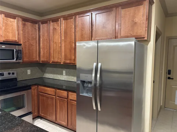 a kitchen with a refrigerator a microwave a sink and cabinets