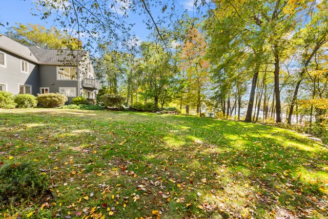 a view of a hallway to a livingroom with wooden floor and furniture