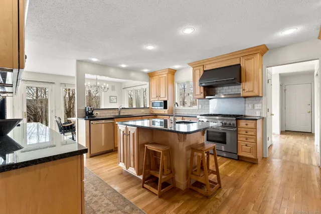 a kitchen with stainless steel appliances granite countertop a sink stove and cabinets