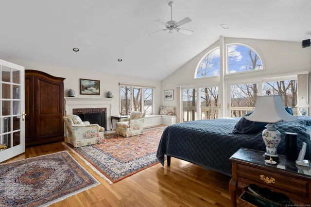 a spacious bedroom with a bed a couch and a large window
