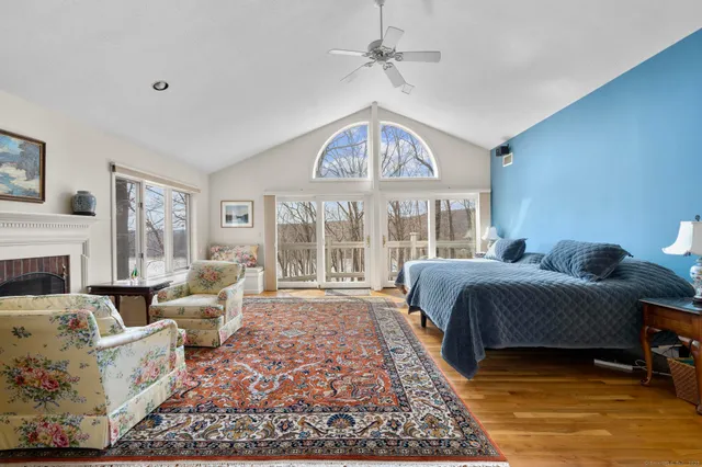 a bathroom with double vanity sink a two mirror a window a bathtub and a vanity
