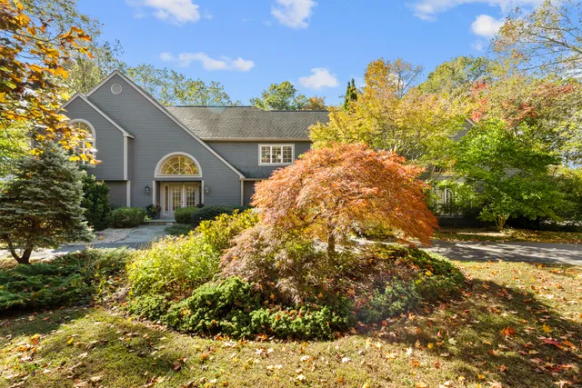 a view of a house with a yard and potted plants