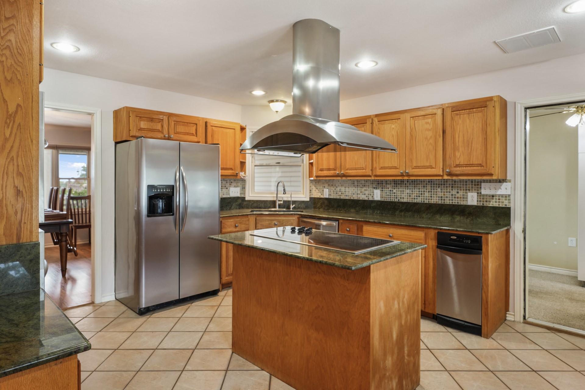 6625 East Post Road Kyle, TX 78640 - Photo 11 of 46 a kitchen with stainless steel appliances granite countertop a sink a stove and a refrigerator