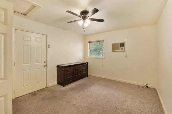 an empty room with closet and a ceiling fan