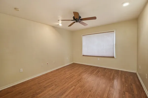 a view of a room with wooden floor and a ceiling fan