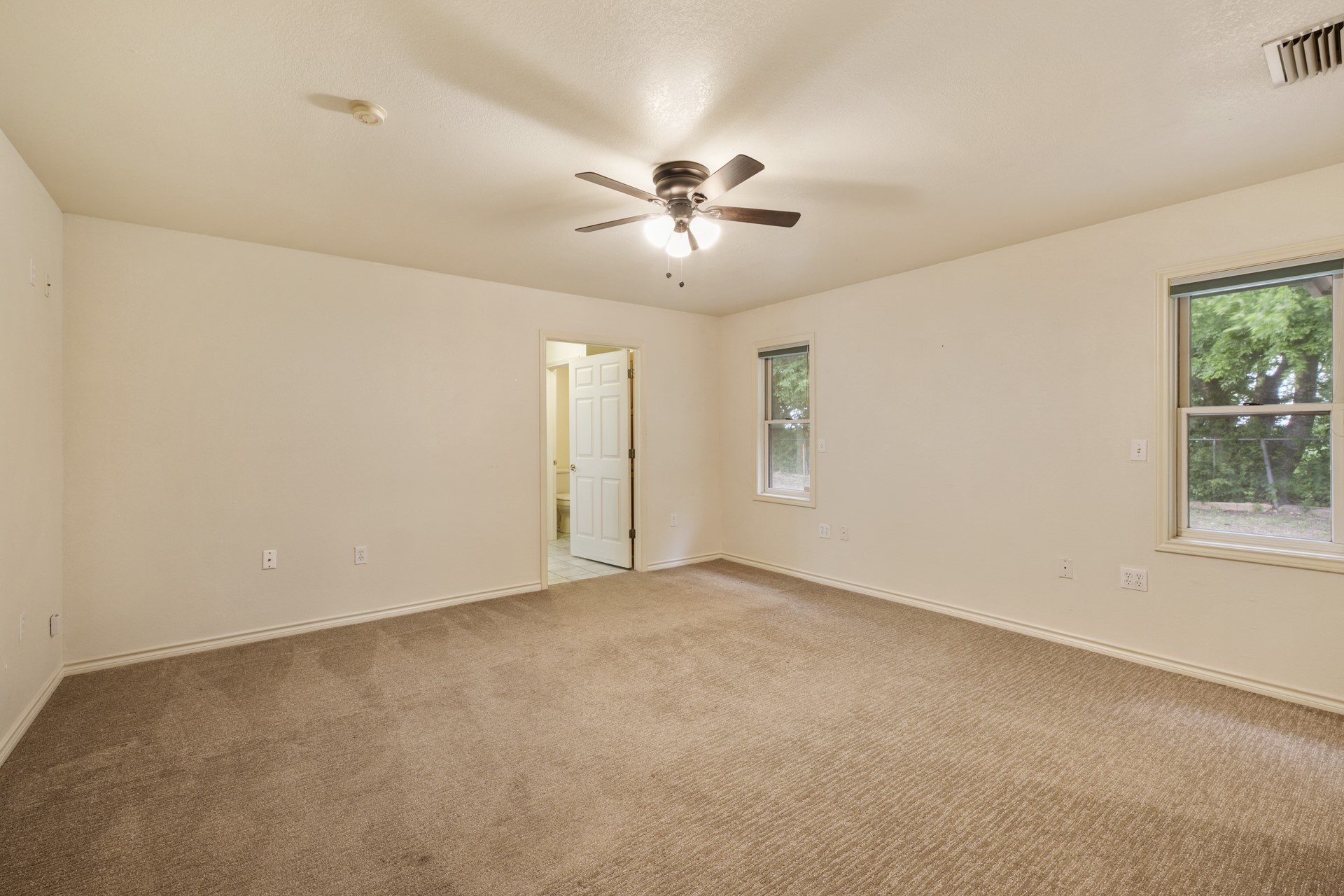 6625 East Post Road Kyle, TX 78640 - Photo 31 of 46 an empty room with windows and fan