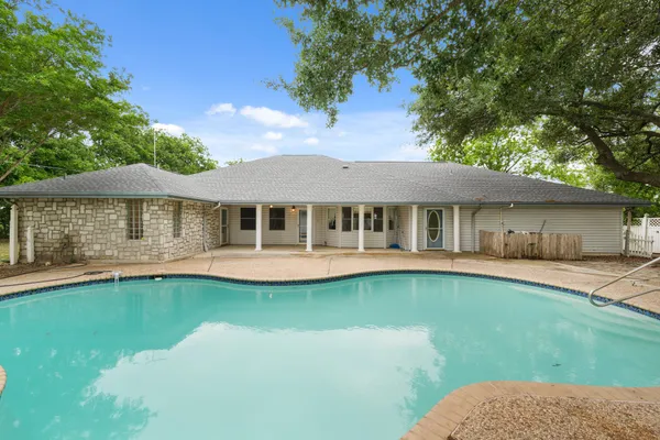 a view of a house with swimming pool and sitting area