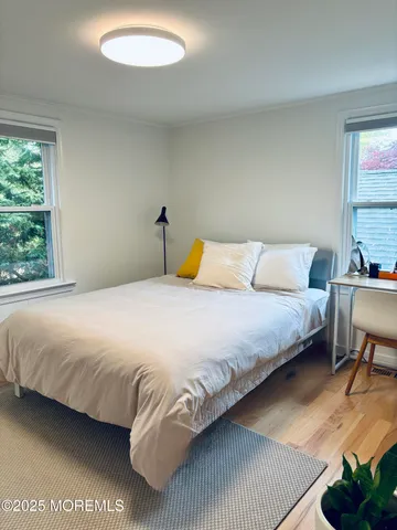 a bedroom with a bed and wooden floor