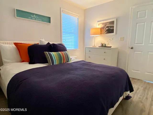 a bedroom with a bed and painting on the wall