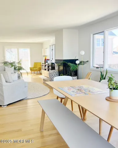 a living room with stainless steel appliances kitchen island granite countertop furniture and a wooden floor