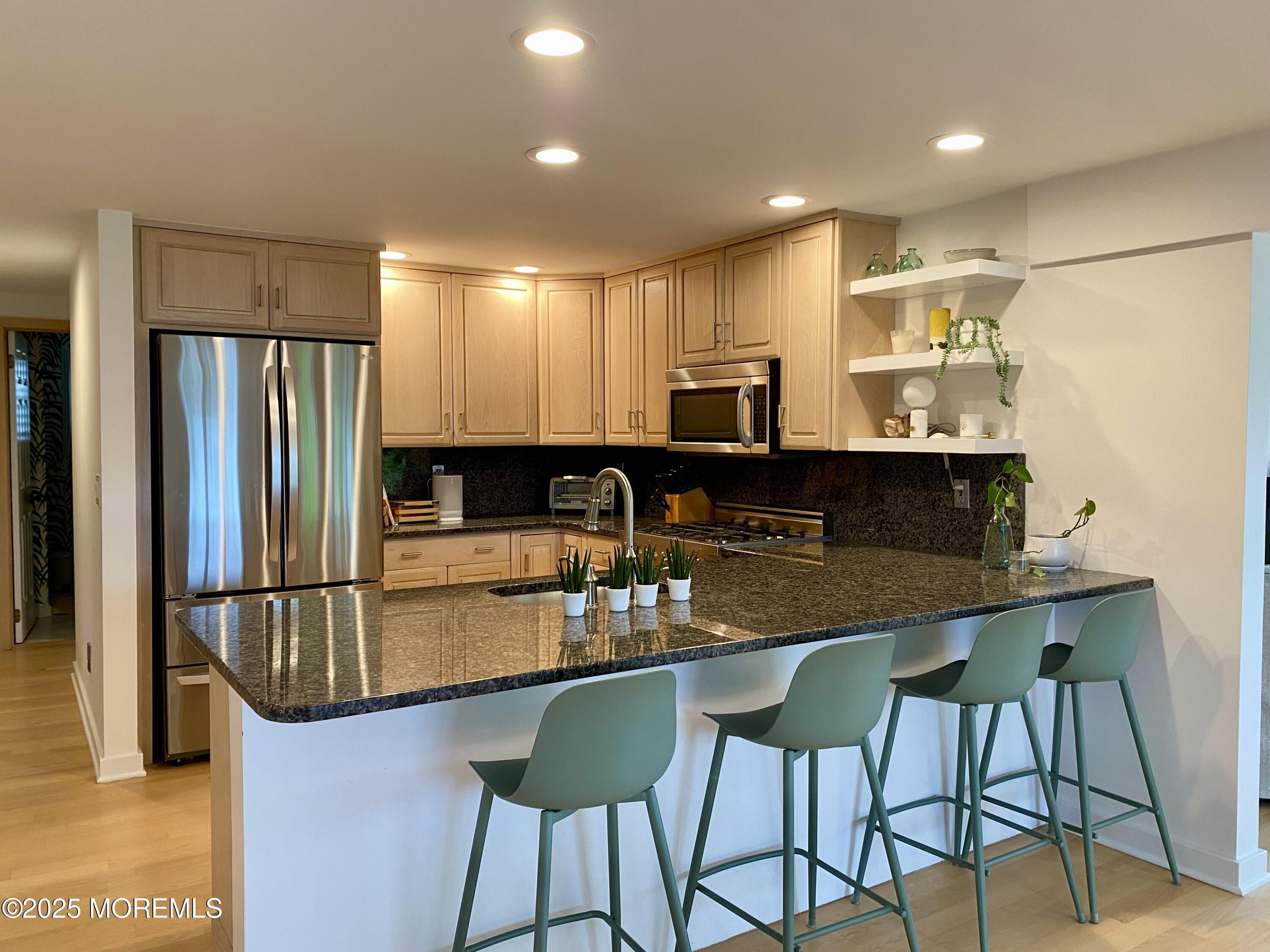 121 Bridge Avenue Bay Head, NJ 08742 - Photo 10 of 22 a kitchen with kitchen island granite countertop a table chairs microwave and refrigerator