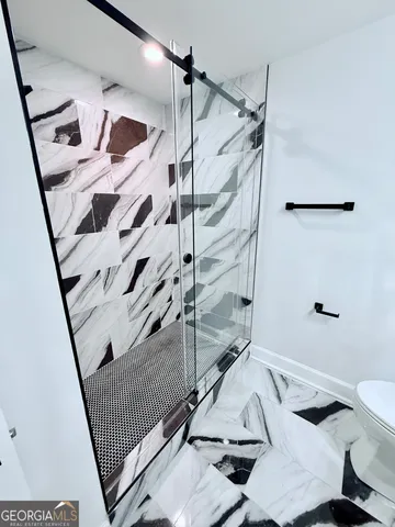 a bathroom with a granite countertop sink and a toilet