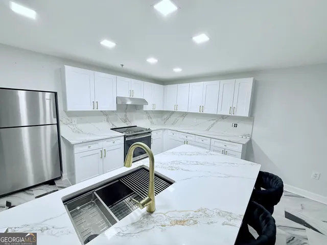 a kitchen with a refrigerator sink and cabinets