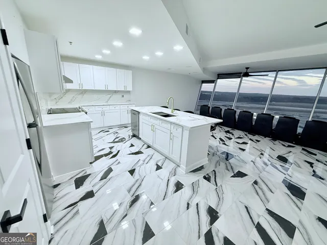 a kitchen with a sink a refrigerator and cabinets