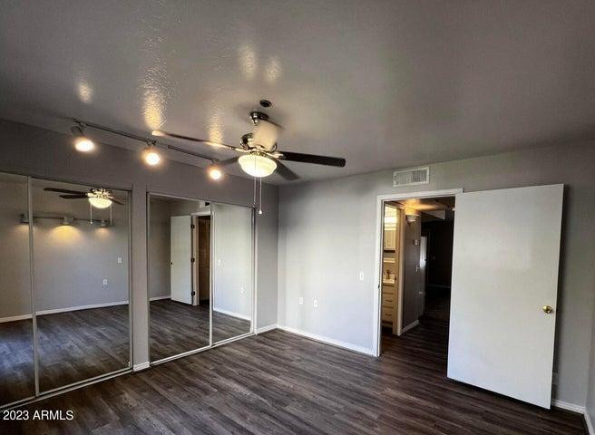 an empty room with wooden floor and natural light