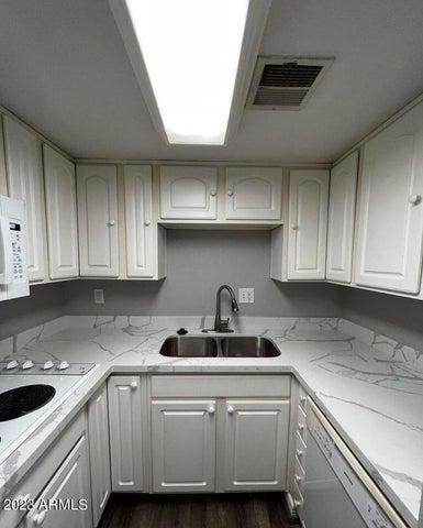 12221 West Bell Road, Unit 224 Surprise, AZ 85378 - Photo 3 of 12 a kitchen with a sink and cabinets