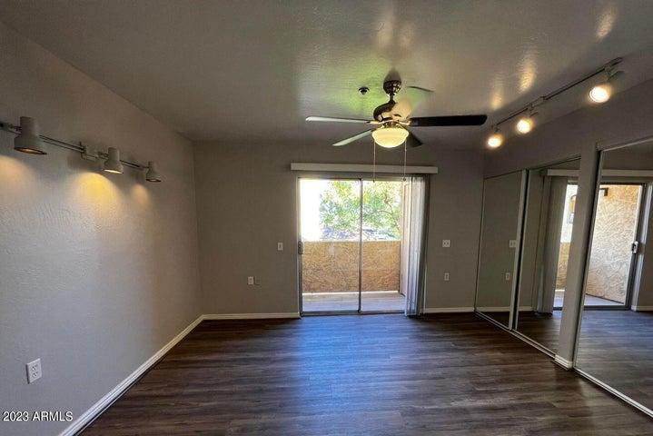 12221 West Bell Road, Unit 224 Surprise, AZ 85378 - Photo 7 of 12 an empty room with wooden floor and windows