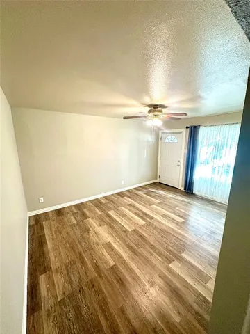 en empty room with wooden floor and windows