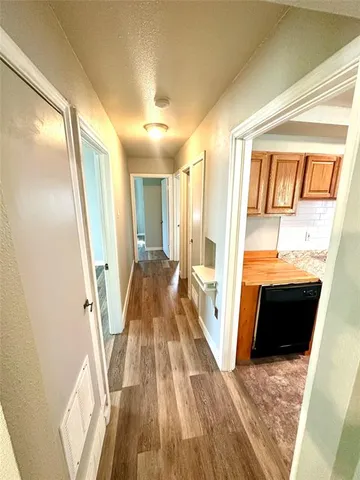 a view of front door and bedroom with wooden floor