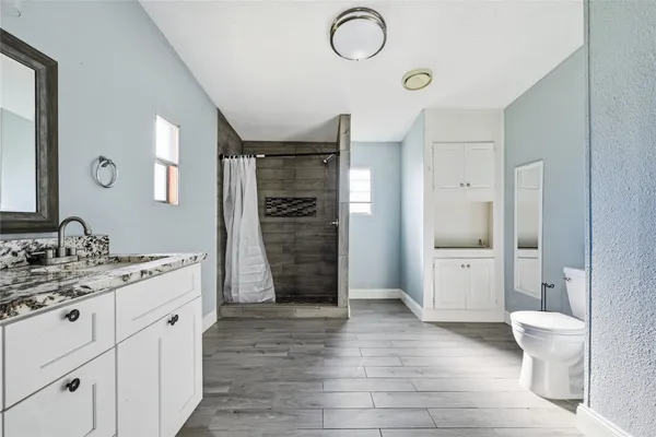 a spacious bathroom with a double vanity sink a toilet and a shower