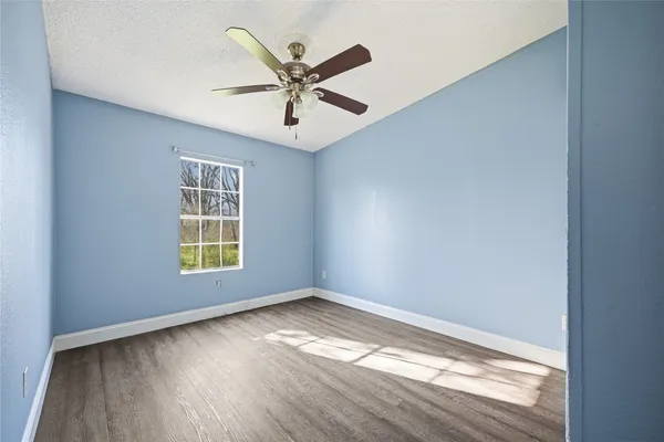 a view of a big room with wooden floor and windows