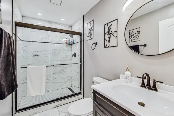 a bathroom with a sink a toilet and shower