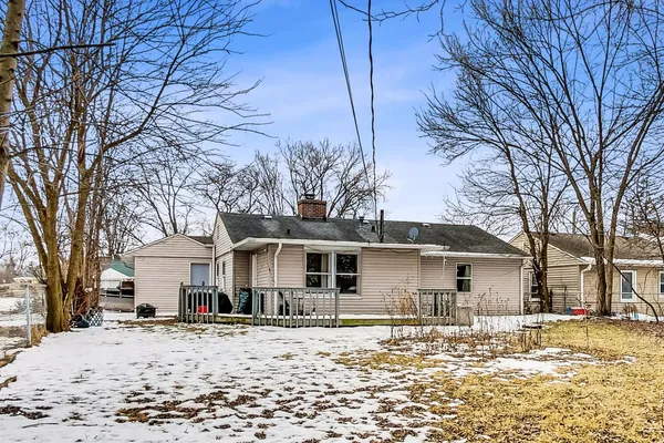a front view of a house with a yard covered in snow