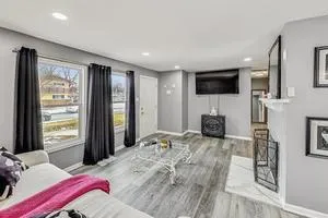 a bedroom with a bed a television and wooden floor