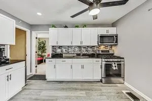a kitchen with stainless steel appliances granite countertop a stove a sink and a microwave