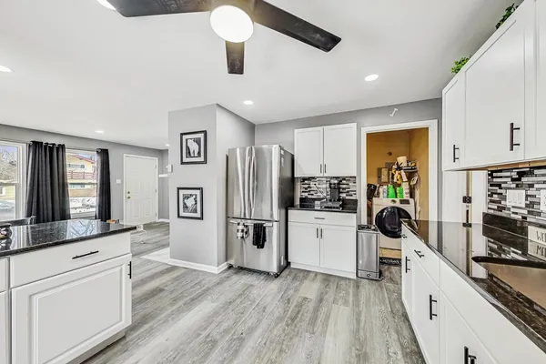 a kitchen with white cabinets and stainless steel appliances
