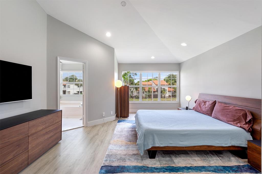 21470 St Andrews Grand Circle, Unit 12 Boca Raton, FL 33486 - Photo 13 of 26 a spacious bedroom with a bed and wooden floor