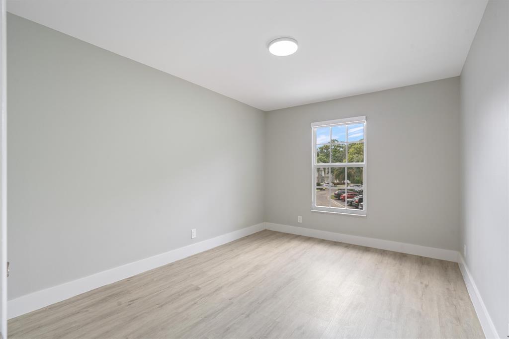 21470 St Andrews Grand Circle, Unit 12 Boca Raton, FL 33486 - Photo 22 of 26 an empty room with wooden floor and windows