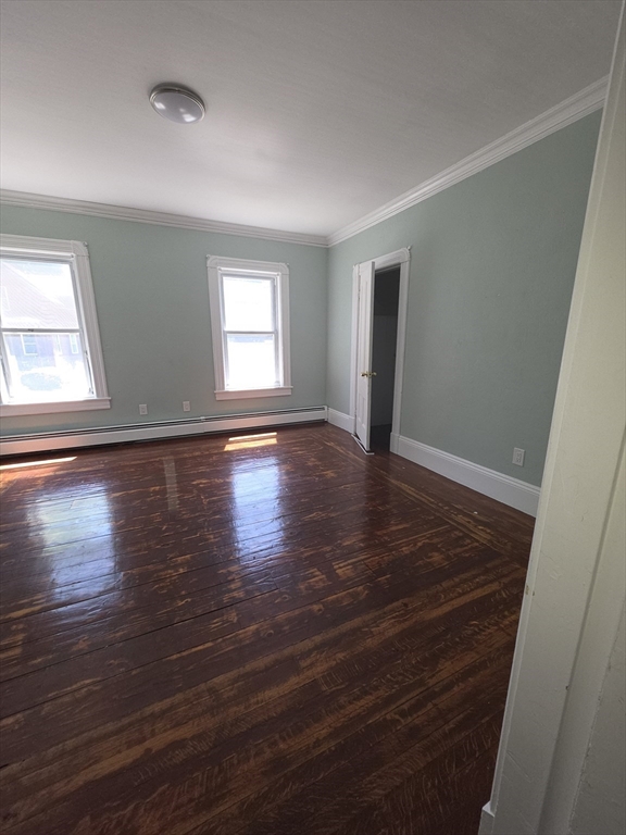 44-th 19th Street, Unit 2 Lowell, MA 01850 - Photo 4 of 5 an empty room with wooden floor and windows