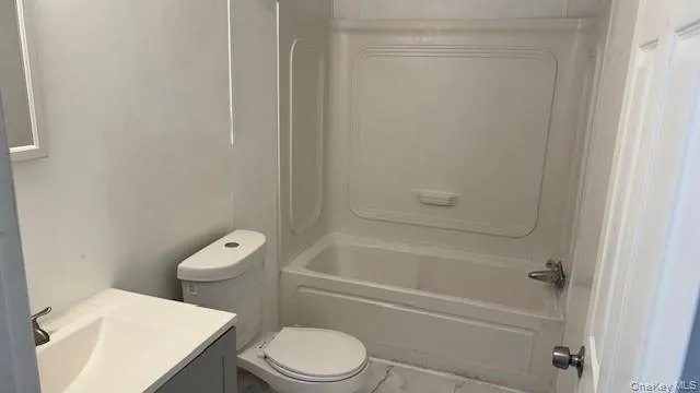 a white toilet sitting next to a bathtub