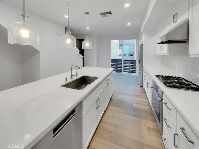 a kitchen with kitchen island a sink and stove