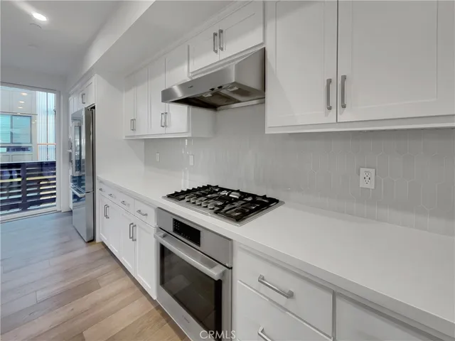 a kitchen with granite countertop a sink and a stove top oven