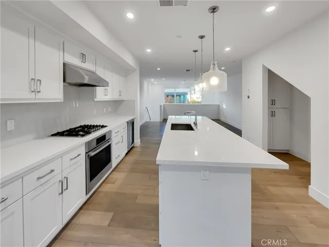 a kitchen with granite countertop a sink a counter top space and stainless steel appliances