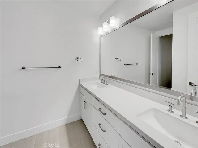 a spacious bathroom with a double vanity sink and a mirror