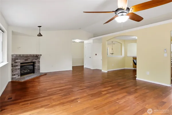 a view of empty room with wooden floor and fireplace
